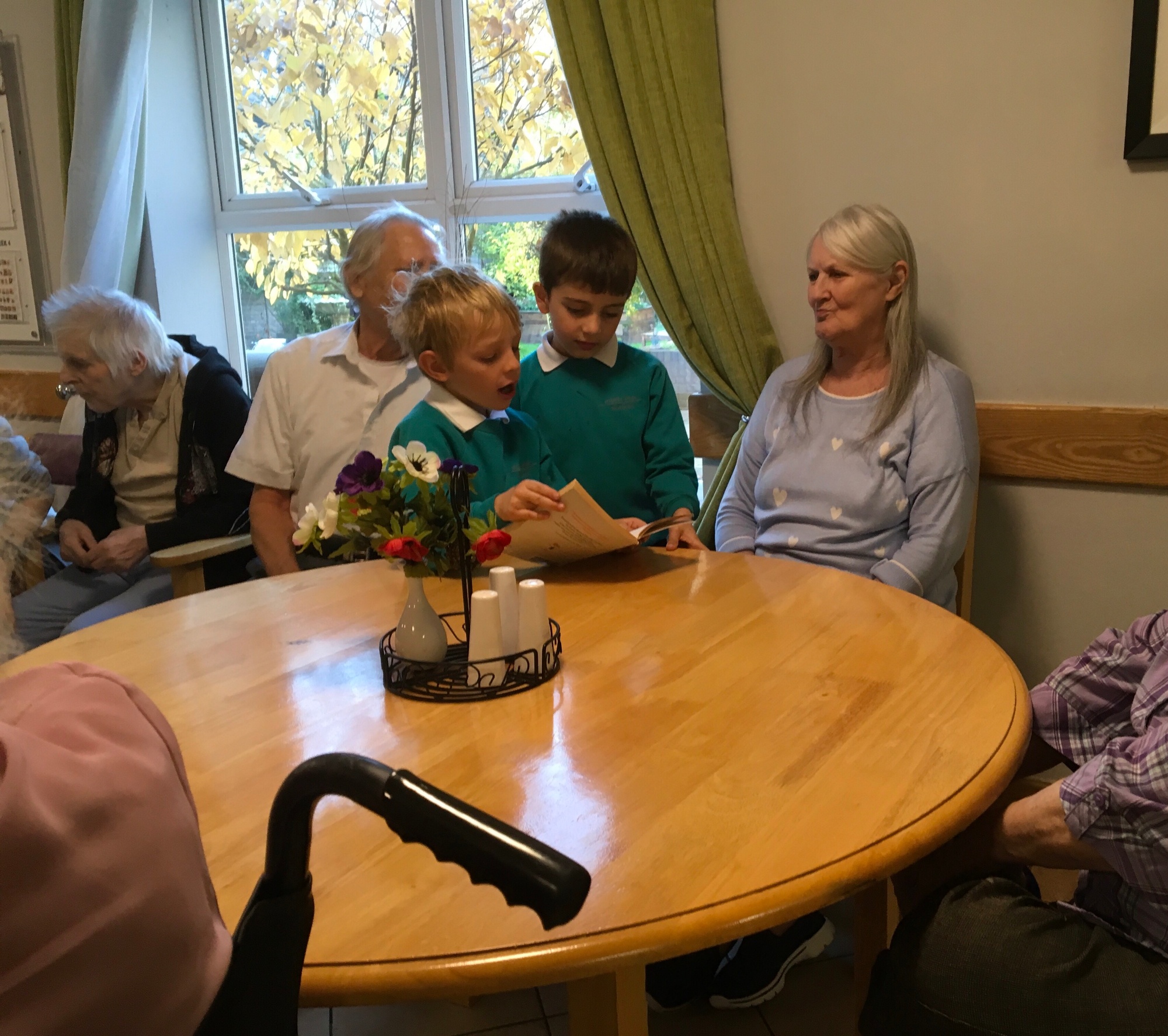 Two Year 2 boys read a story to a car home resident