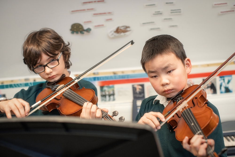 Image of pupils playing the violin to illustrate 'Make music' page